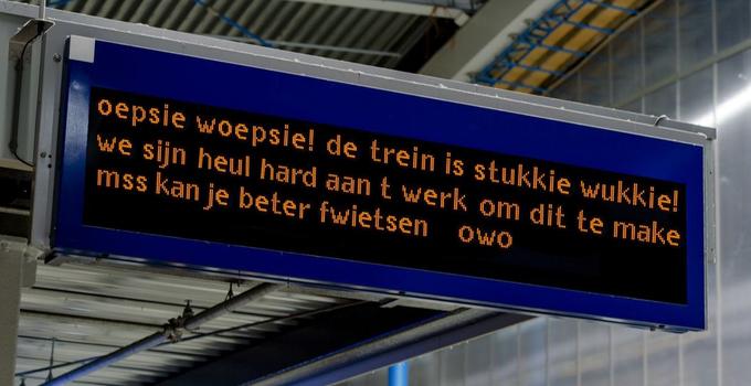 a photo of a train station sign reading 'oepsie woepsie! de trein is stukkie wukkie! we sijn heul hard aan t werk om dit te make mss kan je beter fwietsen owo'